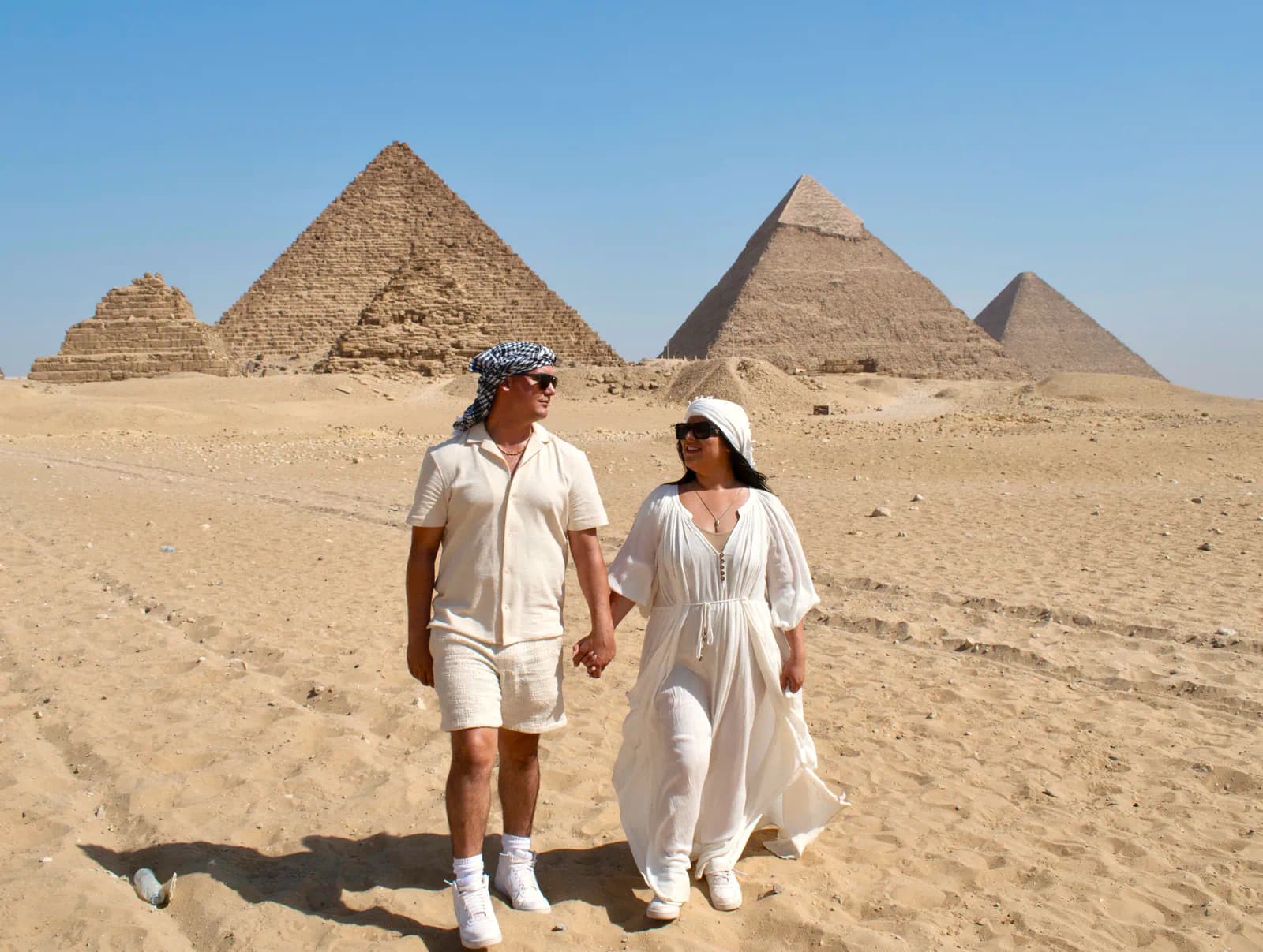 Camel riders with the Pyramids of Giza at dawn